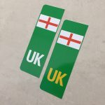 Two green columns. UK in white at the base of one column. UK in yellow on the other. Both stickers have the England flag at the top.
