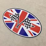 UNION JACK CHEQUERED OVAL STICKER. Two crossed black and white chequered flags overlay an oval Union Jack.