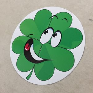 LUCKY CLOVERLEAF STICKER. A humorous sticker. A green cloverleaf with happy eyes and a broad smile. The mouth is open displaying white teeth and a red tongue.