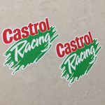 A white sticker with a green brush stroke in the centre. Castrol in red and Racing in white lettering overlays this.