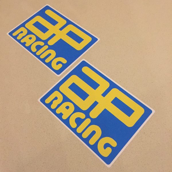 AP RACING STICKERS. AP Racing in bold yellow uppercase lettering on a blue rectangular sticker.
