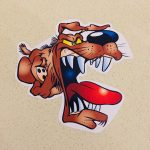 ANGRY DOG STICKERS. A cartoon character of an angry dog with a brown coat, a big nose, floppy ears and yellow eyes. The jaws are wide open displaying sharp white teeth and a red tongue.