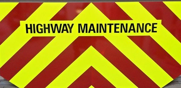 HIGHWAY MAINTENANCE STICKER. Highway Maintenance in black uppercase lettering on a fluorescent yellow sticker.